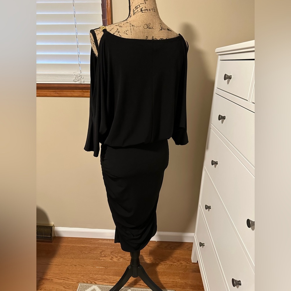 Black knee-length dress with gold chain detail on shoulder & side ruching.